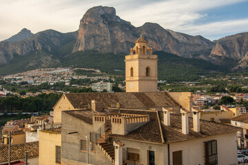 Obraz premium View of the town of Polop de la Marina with medieval Church of San Pedro and the high mountains at the back in Marina Baixa, Alicante, Spain