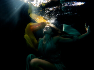 Halee Grindo swimming underwater with long dresss and chiffon