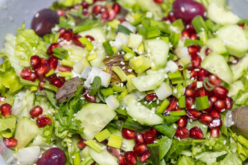 Fresh salad with a mix of fruits and vegetables. Lettuce, arugula, baby spinach, cucumber,...