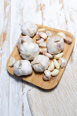 Ripe garlic cloves in bamboo plate. Unpeeled garlic top view.