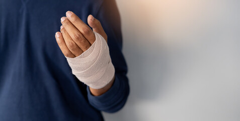 close up adult man hand with bandage support after get injured by accident for insurance claim and health lifestyle concept - obrazy, fototapety, plakaty