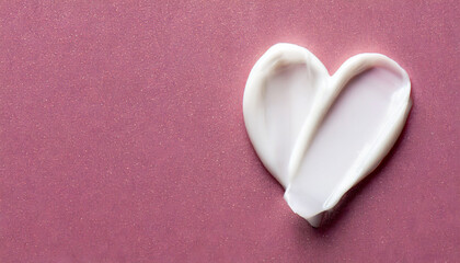 Fototapeta premium White beauty skincare cream swipe smear in heart shape on glitter pink surface