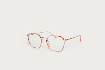 Stylish plastic eyeglasses isolated on light beige background perspective view