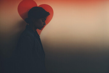 silhouette of a melancholic woman with heart shape on the wall