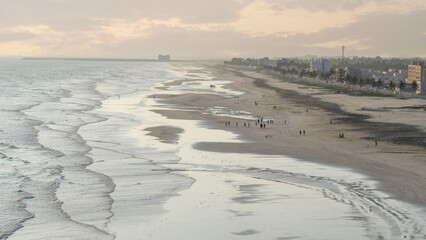 people playing football in the beach during sunset