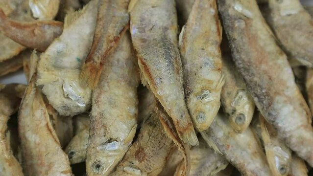 Rotating footage of dried salted fish (ikan asin). Close-up of fish in a traditional market. Flat lay.