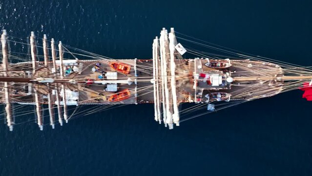 Aerial drone flyover pan video over beautiful 3 mast barque or barc type classic sailing wooden boat anchored in Mediterranean deep blue sea