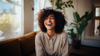 latina afro woman with curly hair smiling sitting on sofa