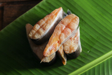 Raw food. Gurameh fish slices on a banana leaf.