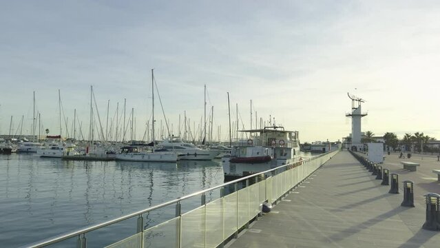 Yachts at the dock in the port Grao of Castellon of winter. The masts of the yachts sway against the blue sky. Spain