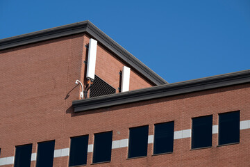 Fototapeta na wymiar Two white antenna on a red brick wall