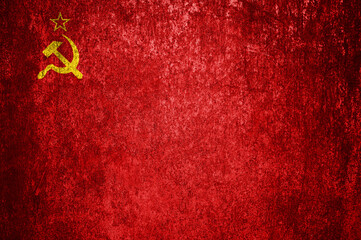 Close-up of the grunge flag of the Soviet Union. Dirty USSR flag on a metal surface.