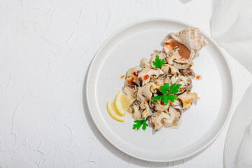 Rapana clam meat with oil, spices and greens. Healthy seafood is rich in omega. Marine decor