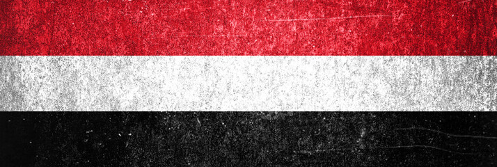 Close-up of Yemen grunge flag. Dirty Yemen flag on a metal surface.