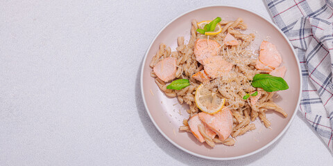 Plant based pasta with salmon, pesto and parmesan cheese. Ready to eat healthy food, served portion