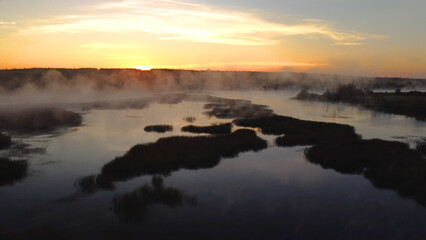 Fototapeta na wymiar Colorful fog over the lake in autumn at dawn