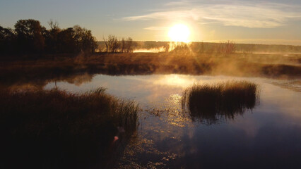 Colorful fog over the lake in autumn at dawn