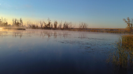 Colorful fog over the lake in autumn at dawn