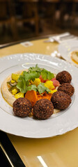 Falafel balls with hummus, close-up. Middle Eastern Arabic food, fried falafel, hummus and vegetables. Delicious and healthy food