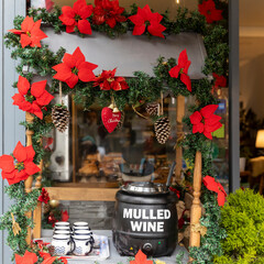 Table for selling mulled wine, decoration in the form of a poinsettia garland, cups for mulled...