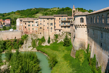 Houses along the river Metauro in Urbania, a small village Marche region; the main town building Palazzo Ducale on the right