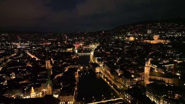 Aerial view over the old town of City of Z&uuml;rich with city lights and traffic on a dark winter night. Movie shot January 5th, 2024, Zurich, Switzerland.