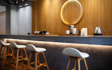 Seat and wooden counter with coffee equipment on counter bar with wooden wall on background