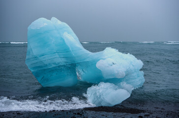 Blue Iceberg at the Black Breiðamerkursandur Beach in Southern Iceland