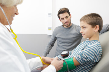 little boy visiting doctor in hospital measuring blood pressure