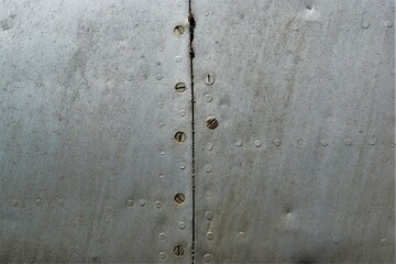 A fragment of an old dirty fuselage with rivets and bolts