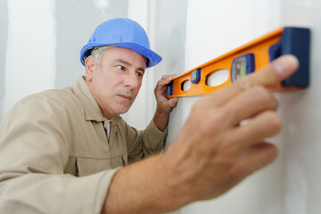 a man is measuring a wall