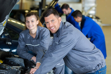 portrait of automotive mechanic with female apprentice