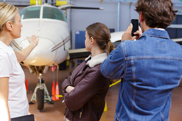 man photographing aircraft while visiting hangar