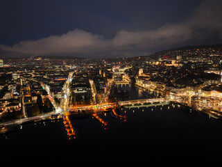 Aerial view of Swiss City of Zürich with cityscape, skyline, city lights, Limmat River and Lake Zürich on a dark winter night. Photo taken January 5th, 2024, Zurich, Switzerland.