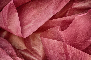 A background of crumpled pink wrapping paper. Close up.