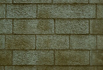 An old, mossy wall built of stone blocks. High quality photo
