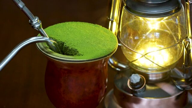 Serving traditional chimarrão prepared with yerba mate (Ilex paraguariensis). Serving with gooseneck kettle, video in selective focus