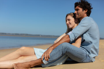 pretty girl cuddling with boyfriend on beach