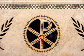 Close-up on decorative christian symbol on church wall in Italy