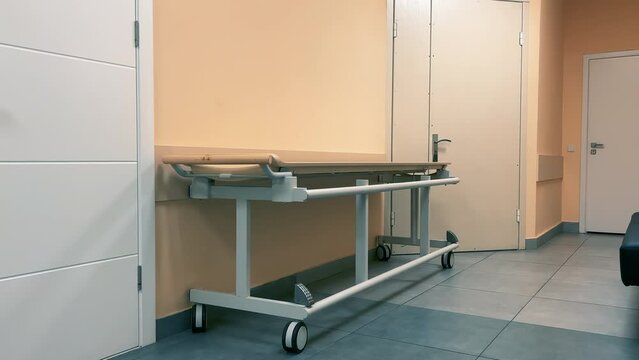 Modern empty hospital or clinic corridor with medical bed or hospital cot