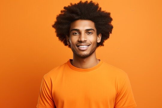 Young man with afro hair wearing orange t-shirt smiling on orange background. Generative AI.