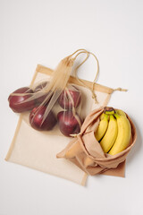 Apples and bananas in reusable bags.
