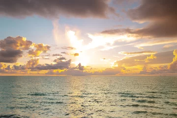 Fototapeten Sunset on sea. Beach sunrise with cloudy sky. © Volodymyr