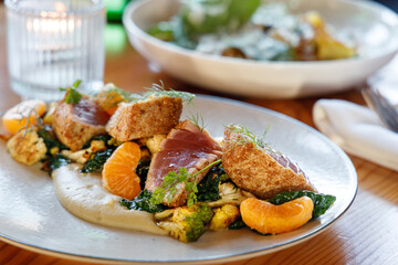 Seared Ahi Tuna over a bed of mashed potatoes with tangerines, broccoli, kale, dill. 