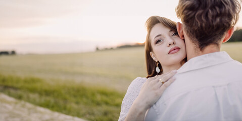 couple in love on a date in nature hugging in a white outfit in the summer. Love, happiness of a young Caucasian couple.