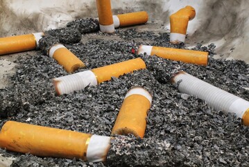 Cigarette butts in ashtray. Bad addiction. Debris after smoking. World No Tobacco Day concept. cigarettes damage the lungs. Health care. Stop smoking. Nicotine addiction and serious health problems