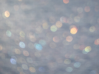 Artistic, shiny, purposely blurred background with white and colorful bokeh effect of snow in...