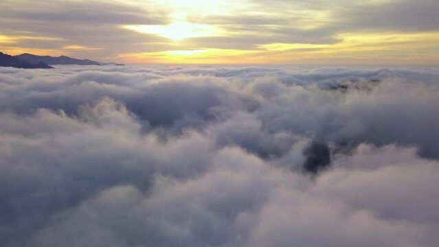 Fly above clouds in misty nature heaven landscape at golden sunrise Aerial view