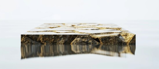 Empty trendy platform for displaying products, with abstract golden cobblestones and reflection in water, on a minimal white background.