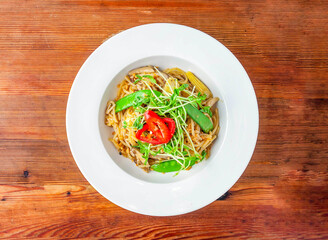 vegetable aglio e olio with baby corn, mushroom and tomato served in dish isolated on wooden table top view of hong kong food